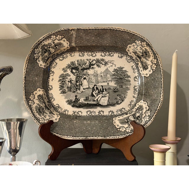 A wonderfully atmospheric mid-19th-century English black transfer-printed earthenware platter featuring an elaborate...