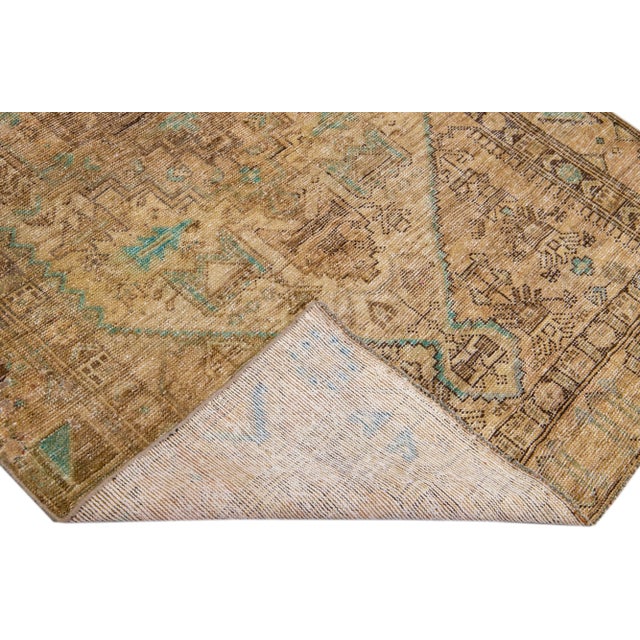 Beautiful vintage Persian distressed hand-knotted wool rug with a beige color field. This piece has a tan frame and...