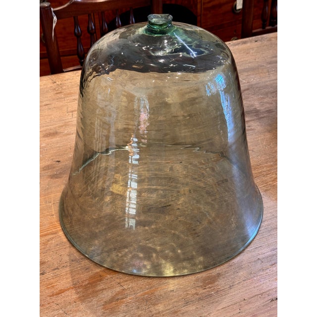 A cloche with a bell-shaped form, shown without a finial; the top appears broken where a knob would have been. The body...