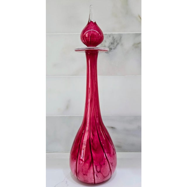This vintage Mtarfa art glass decanter is hand-blown in Malta in a rich cranberry tone, with dramatic internal veining...