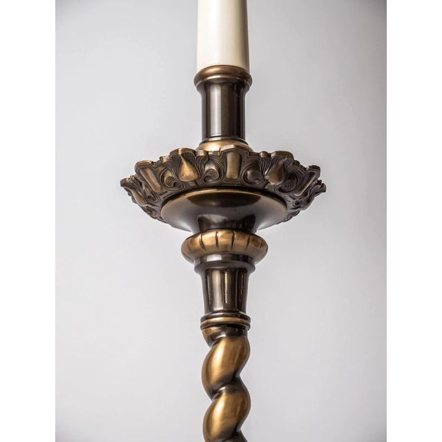 Floor lamp made of cast brass in the baroque style with a fabric shade. The shade is finished with decorative ports and...