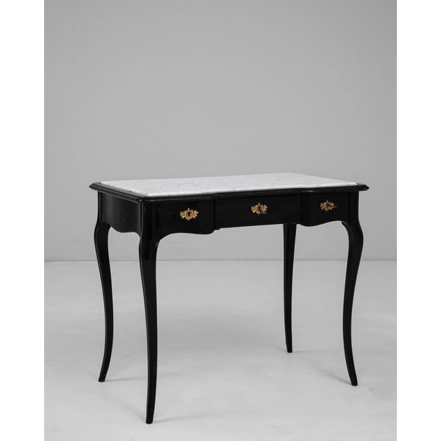 1900s French black-patinated side table with a white marble top, showcasing the refined elegance of early 20th-century...