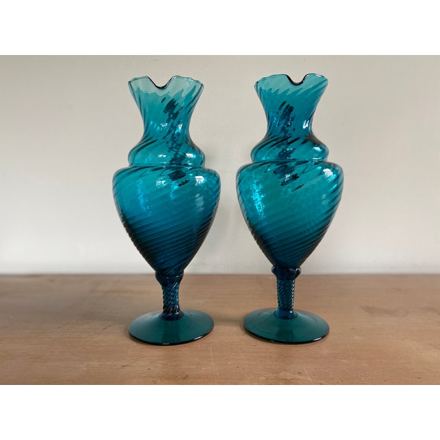 A fantastic pair of 1950s blue Empoli glass ewers with wonderfully twisted stems, bodies and handles. Condition is mint....