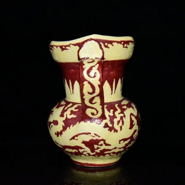 This distinctive monk’s cap porcelain ewer features a deep red ground with raised pale yellow decorative motifs. The...