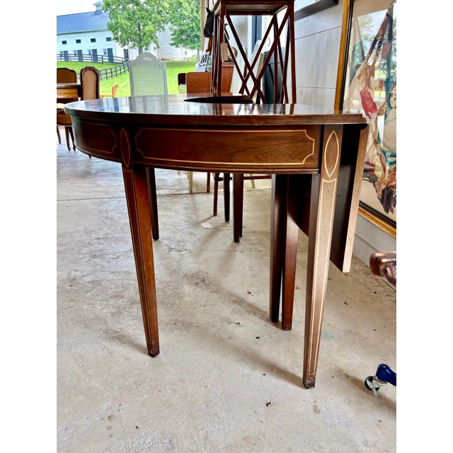 Classic Federal Style Cherry Hunt Table, Late 18th Century to Early 19th century. With a versatile Demilune shape, with...