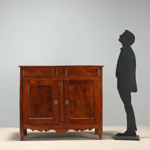 Baroque walnut sideboard dating from the early 19th century, originating from France. This piece features a refined...