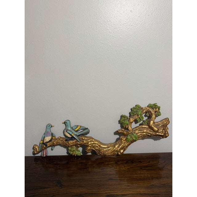 Charming vintage wall sculpture featuring two colorful birds perched on a beautifully sculpted tree branch. The branch is...