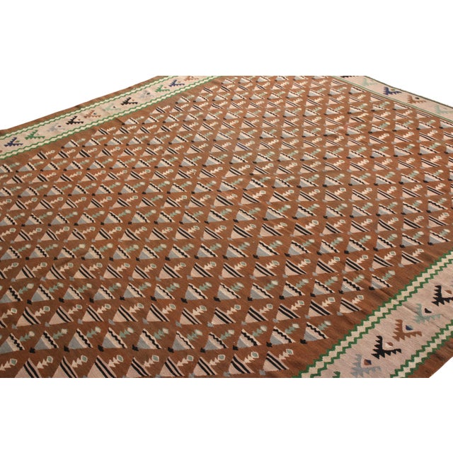 Handwoven in a wool flat weave originating from Turkey circa 1950-1960, this vintage Kilim rug enjoys a mid-century...