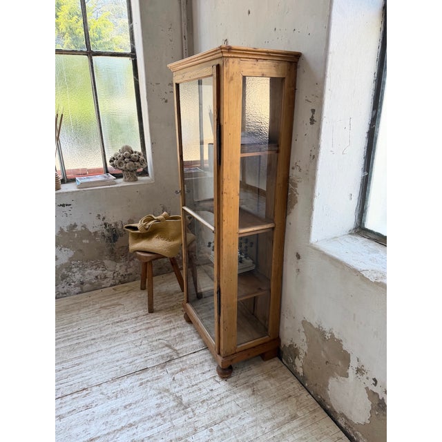 Antique english pine display cabinet from the 18th century. we love its clean lines, its three glass sides with a paneled...