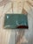 An elegant footed box carved from natural banded stone (likely onyx or marble) in soft celadon/sage green with dramatic...