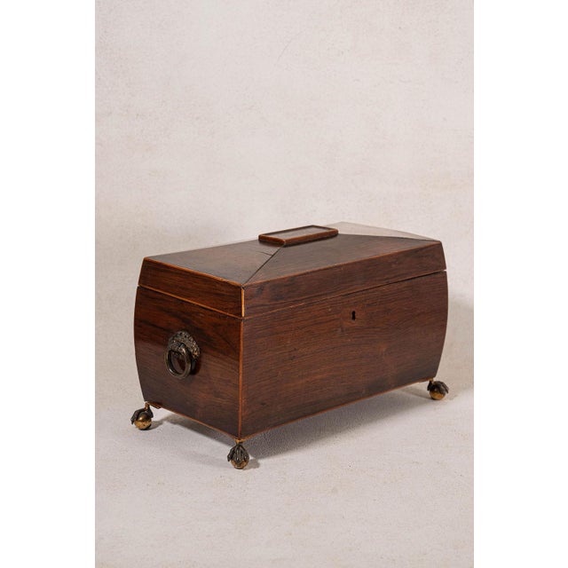 Georgian rosewood tea caddy with brass side handles, brass claw feet, original hardware, and a green-lined interior. Rich...