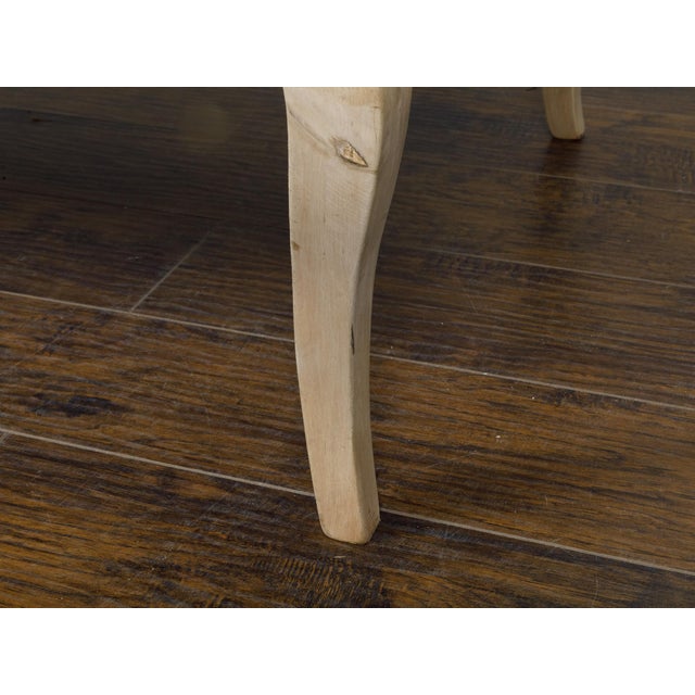 A French Louis XV style bleached fruitwood coffee table from the 19th century with butterfly veneer and carved cabriole...