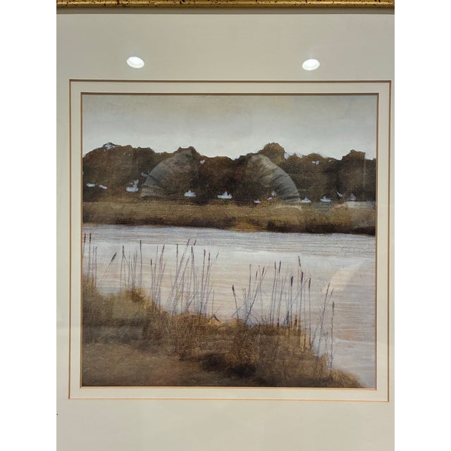 An elegant framed landscape print by Trowbridge, depicting a peaceful waterside scene with gently flowing water, delicate...
