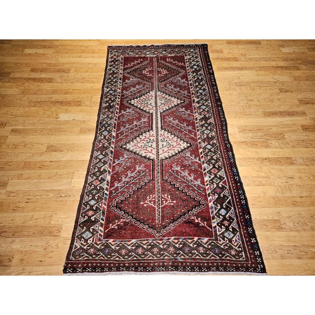 "This vintage Persian Shiraz tribal rug, crafted in Southwestern Persia in the mid-20th century, features a compelling...