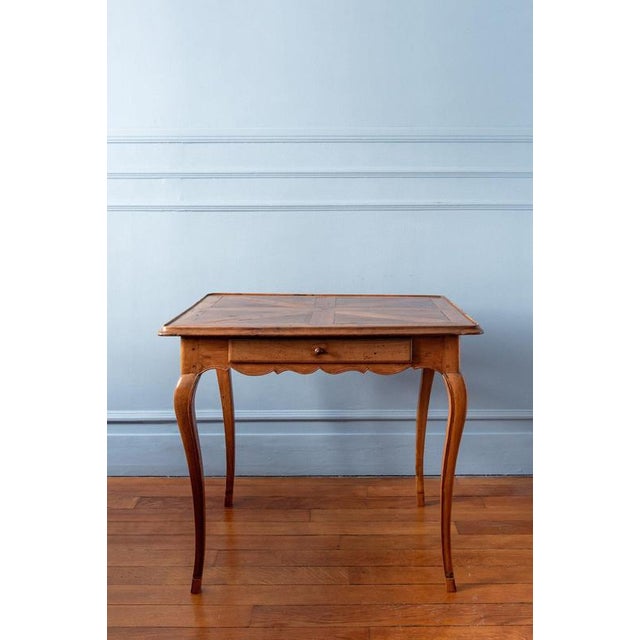 A provincial french louis xv cabaret table in walnut, c. 1750. The top features a striking star-shaped parquetry pattern,...