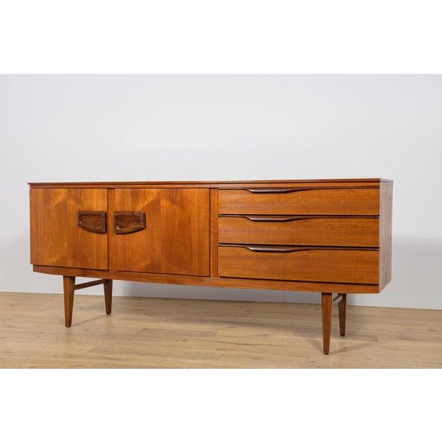 Sideboard manufactured in the 60s in the British Beautility factory. The sideboard has three drawers, a bar and a cabinet....