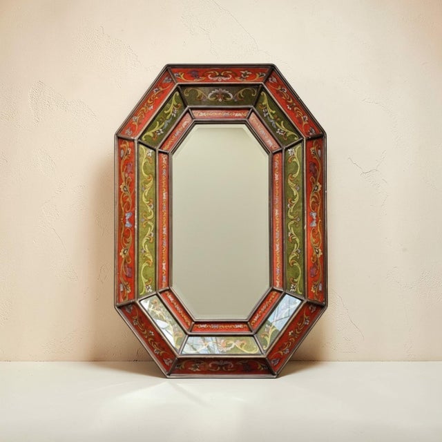 Large decorative mirror featuring a faceted octagonal frame inset with reverse painted glass panels in the tradition of...