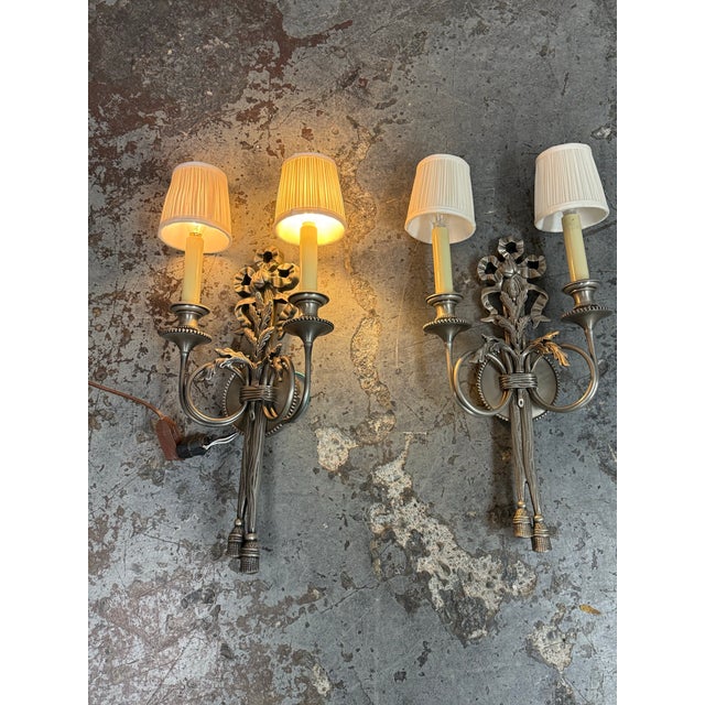 Design Plus Gallery presents a Pair of 19th Century Louis XVI Style Silver Finish Wall Sconces. This matching set reflects...