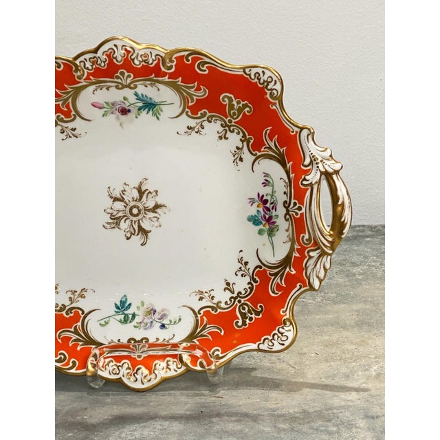 A 19th-century porcelain two-handled dish, with an orange border and gilt highlights, England circa 1860.