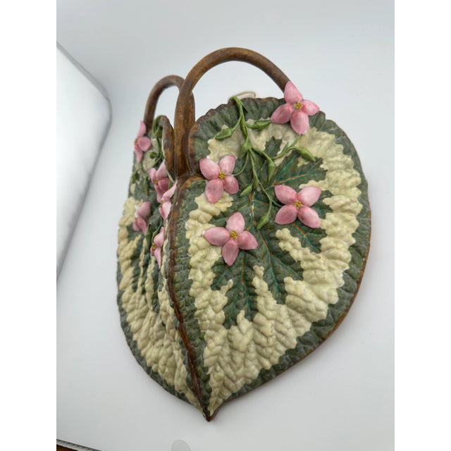 19th-century majolica wall pocket in the form of leaves with vining pink blossoms and branching handles and a bow-shaped...