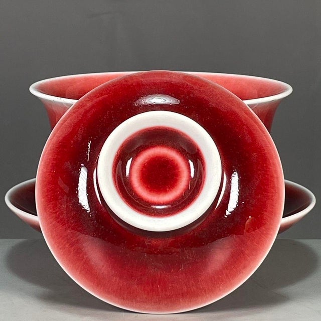 Classic Chinese gaiwan tea vessel finished in striking langyao ox‑blood red glaze, complete with matching lid and saucer....