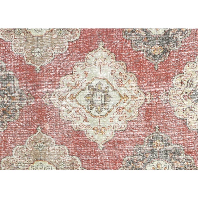 This vintage Turkish Oushak rug, measuring 4'8" by 12'5", is handwoven with wool on a wool foundation in the Oushak region...