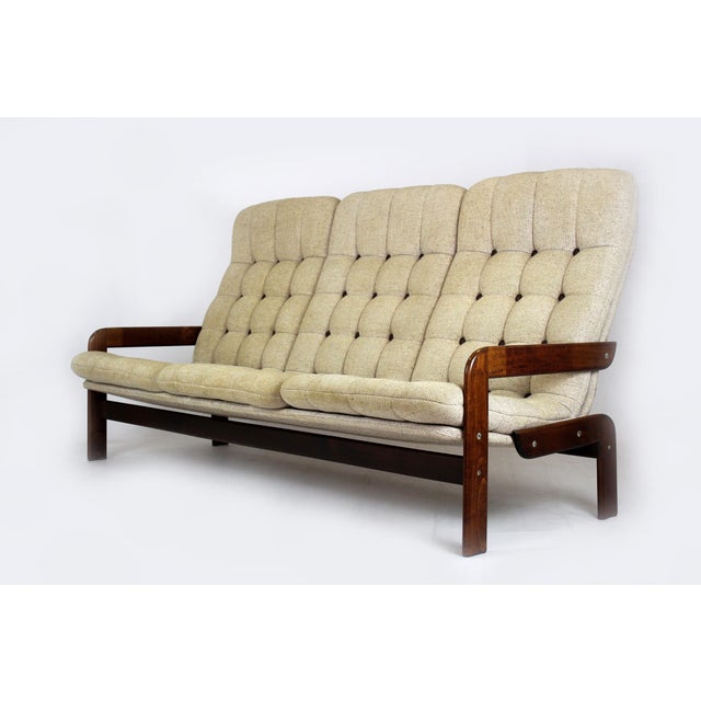 A striking mid-century living room set consisting of a three-seater sofa and a pair of matching low lounge armchairs,...