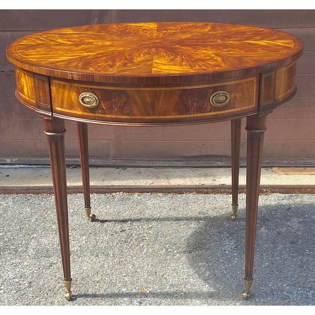 A Pristine Althorp Collection George III Style Crotch Mahogany Double-Drawer Rolling Center Table by Theodore Alexander....