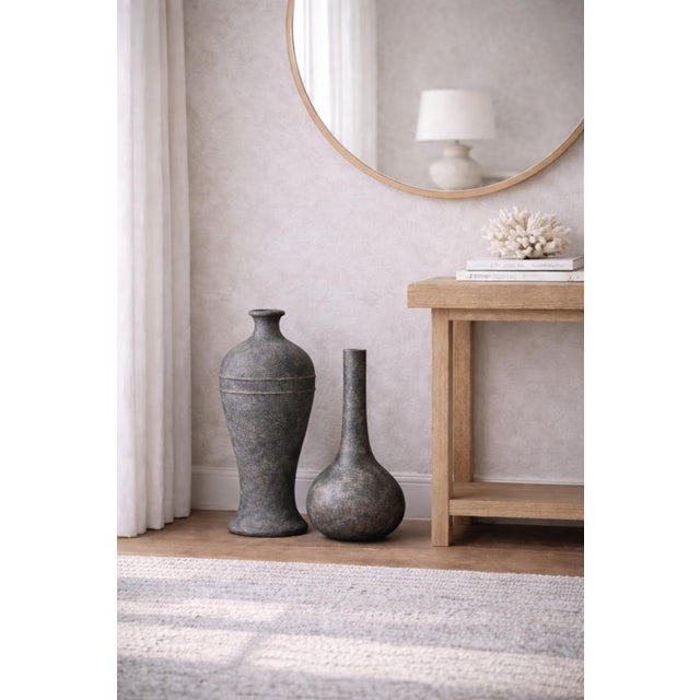A refined pair of organic modern sculptural vessels featuring complementary forms, richly textured surfaces, and a...