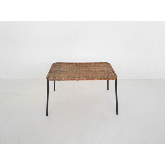 About this item Rattan coffee table with black metal outstanding feet. Small traces of use consistent with age and use.