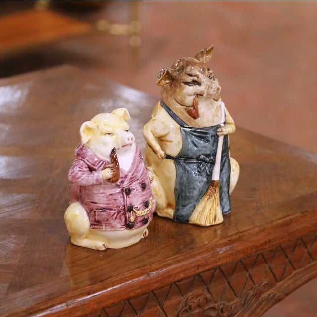 Crafted in Northern France circa 1880, this engaging pair of antique figural faience tobacco jars is executed in the...