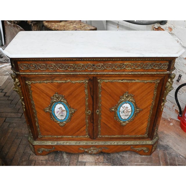 We date this to circa 1860 Features Sevres porcelain plaques with hand painted cherubs White marble top is smooth and chip...