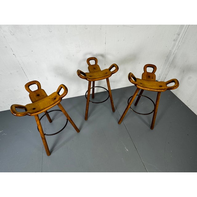 Set of 3 Vintage Brutalist ´Marbella' Bar stools. Three-legged stools in stained beechwood with circular metal footrests,...