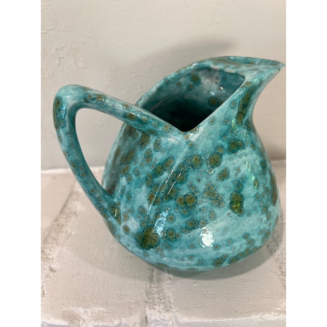 Studio art pottery pitcher in a striking turquoise crystalline spotted glaze, likely mid-to-late 20th century. The base is...