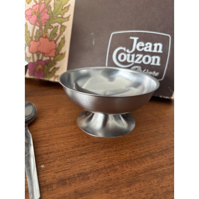 Superb vintage set by Jean Couzon, comprising 6 stainless steel ice cream bowls and 6 matching spoons, presented in its...