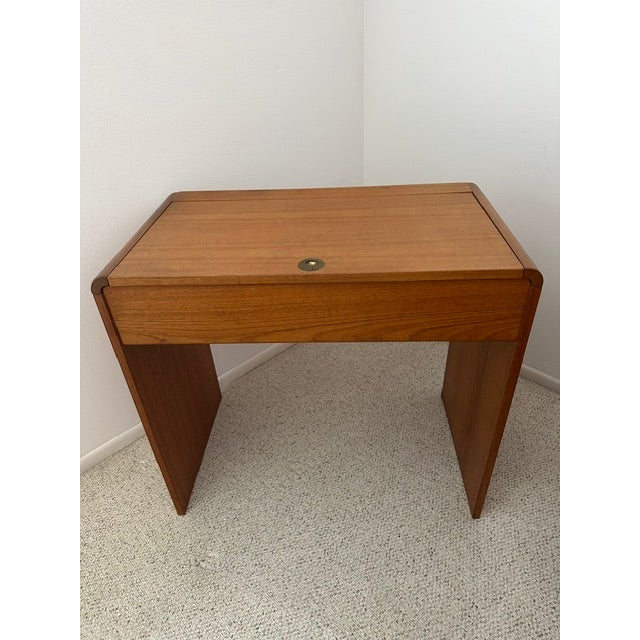 Classic Danish mid-century modern teak dressing table with rounded corners and brass hardware.
