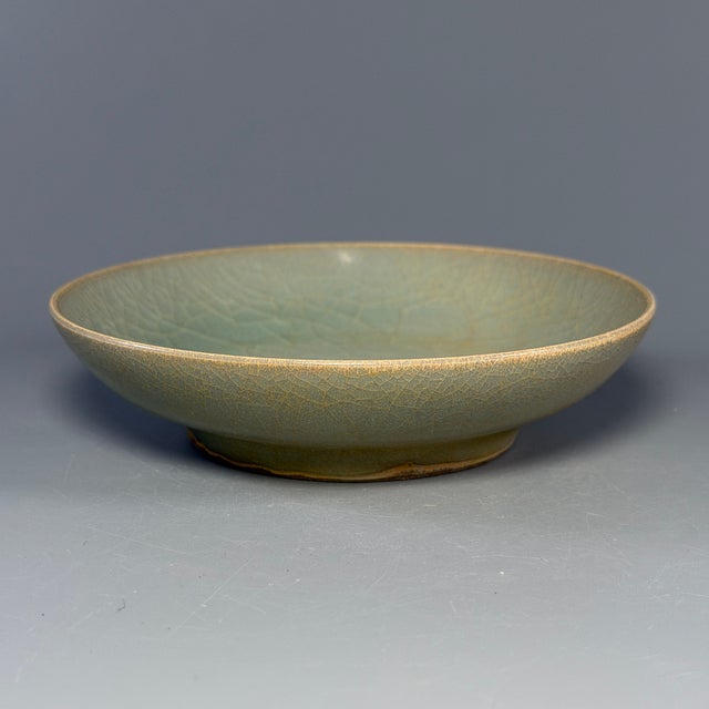 Fine antique Chinese celadon shallow dish. Low‑profile rounded form, covered in natural crackled celadon glaze, tasteful...
