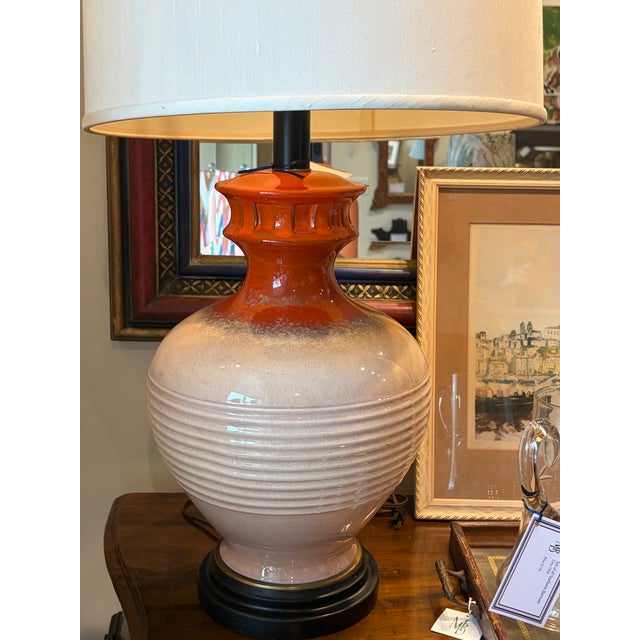 Handsome vintage ceramic lamp with a ribbed cream glaze and a striking persimmon-orange accent. A sophisticated Mid-...