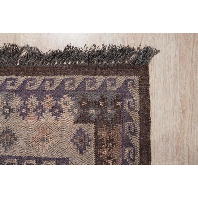 This purple wool rug features a blend of lavender and mauve tones in a durable flat weave construction. Handcrafted in...