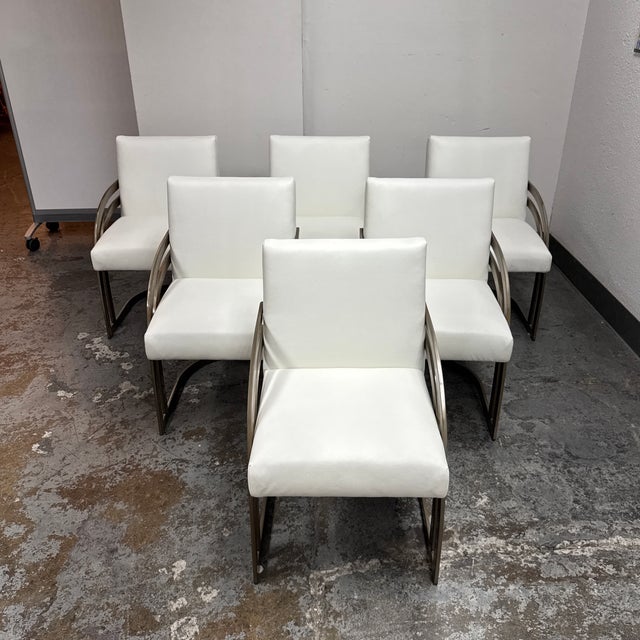 Design Plus Gallery presents a Set of Six Milo Baughman Style Cantilever Dining Chairs. Each chair pairs white vinyl...