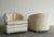 A pair of vintage club chairs with a curved barrel back, channel tufting, and self-covered buttons. The rolled crest and...