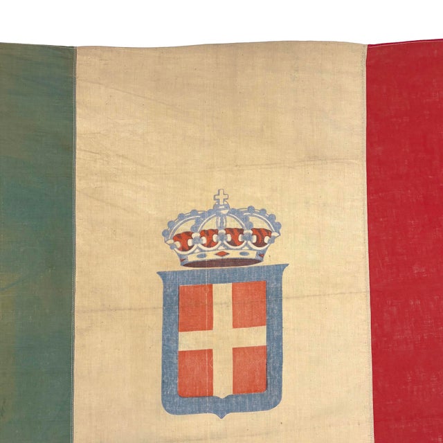 This antique Italian flag is made from a thin cotton cloth, with sewn panels and printed emblem visible on both sides....