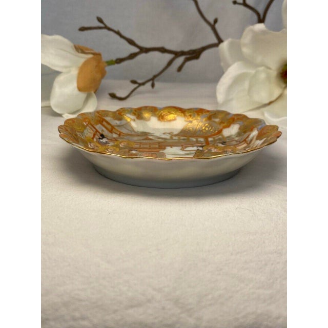 This finely detailed Japanese Satsuma plate dates to the late Meiji period and is richly decorated with a continuous...