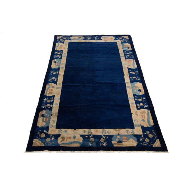 Beautiful antique Chinese Art Deco rug, hand-knotted in wool with a navy blue field and a light brown frame, featuring a...