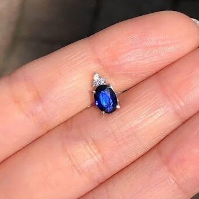 This beautiful pendant features a 0.91 carat oval sapphire gemstone with a natural earth mined diamond triad on the top of...