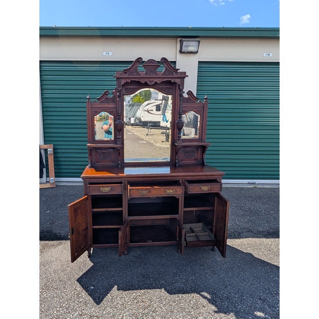 Late 19th early 20th Century mahogany (?) buffet with elaborate, mirror backed top and carved bottom portions. Delicate...