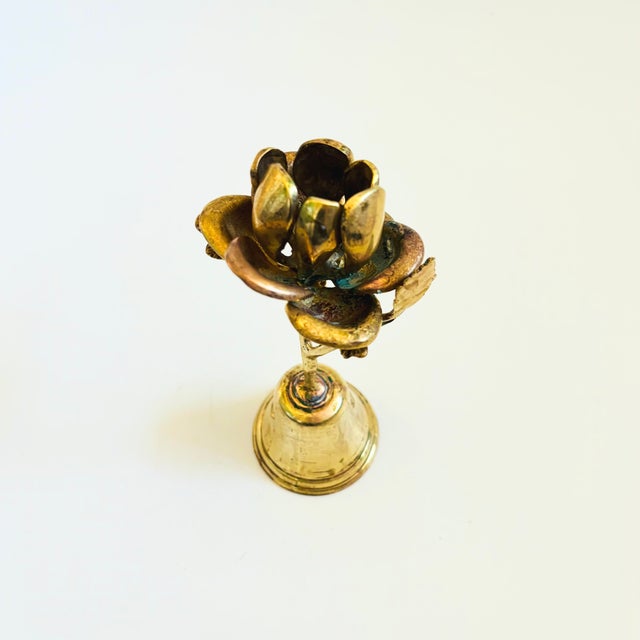 A wonderful vintage brass bell with a flower shaped handle. Measures 2.75"Dia x 7.75"H