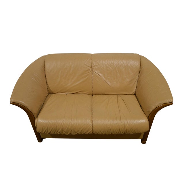 A delightfully modern loveseat by Ekornes (labels affixed). Well made and upholstered with high quality leather....