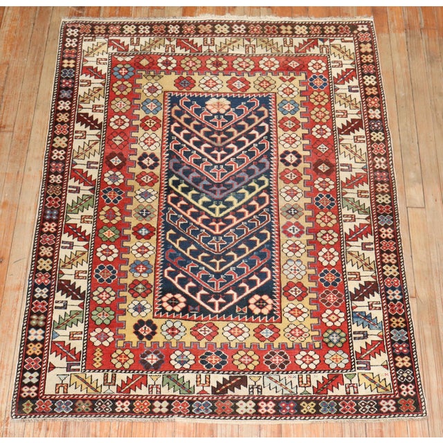 An early 20th century colorful Caucasian rug with a whimsical Directional motif and multi band border Measures: 3'9" x 4'10".