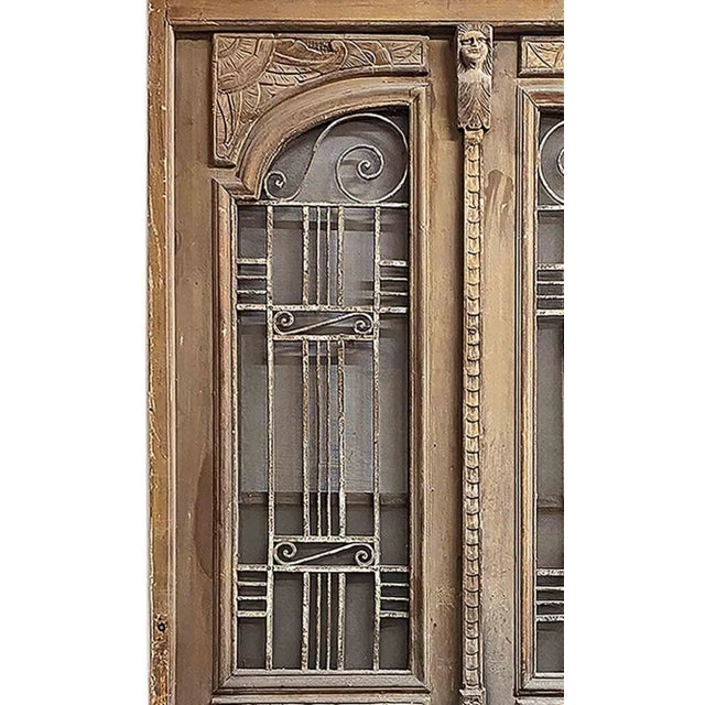 Antique, 1920's Art Deco carved wood and wrought iron entry doors in the original frame. Doors feature a distinctive Art...
